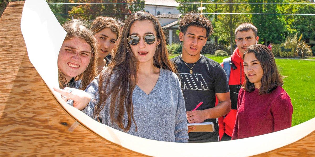 Students examine object during outdoor class