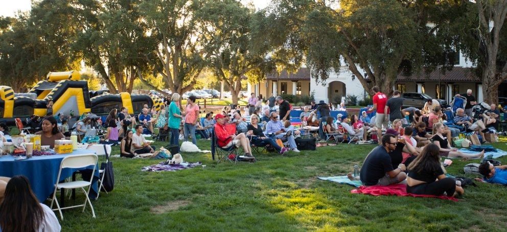 Hundreds of people sit on lawn chairs at Music on the Lawn