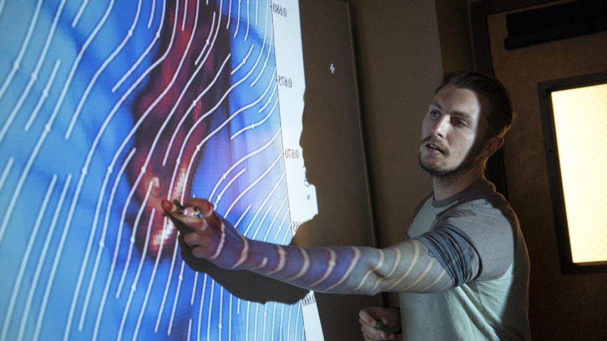 A student pointing data on a white board