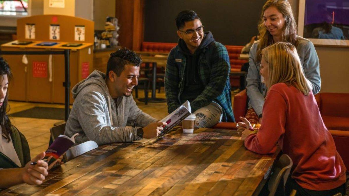 three students gathered by table